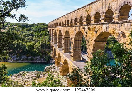 Three-tiered aqueduct Pont du Gard - the highest in Europe.  Provence, spring sunny day. The bridge was built in Roman times on the river Gardon