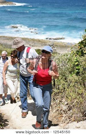 Gruppe von Senior mit Rucksäcken zu Fuß am Meer