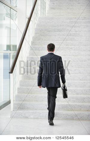 Ung man med en resväska gå i trappor