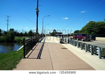 PLAINFIELD, ILLINOIS / UNITED STATES - SEPTEMBER 20, 2015: Pedestrians and vehicles may cross a bridge over the DuPage River in downtown Plainfield, Illinois.