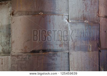 A wall made with rusty big panels