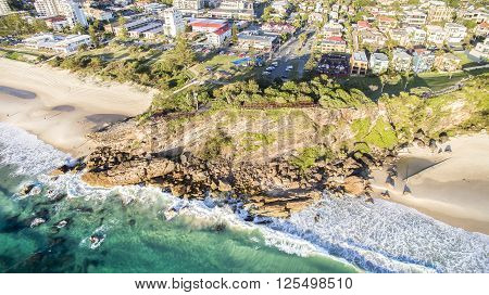 Aerial view of Miami Headland and beach as the sunrise glow hits the foreshore. Gold Coast, Australia