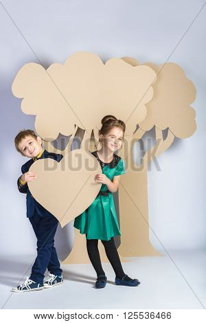 Love concept. Couple of kids. boy and girl with  cardboard trees.