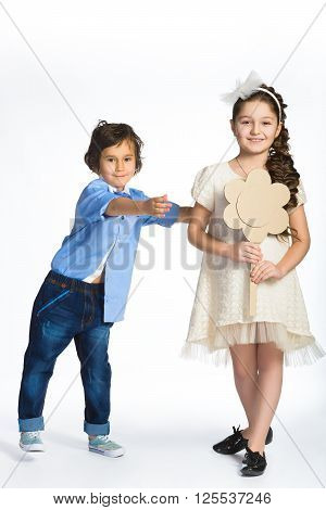 Cute boy and girl or teenagers in full length casual style blue jeans posing.