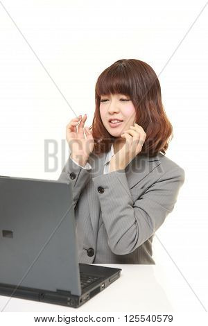 young Japanese businesswoman shocked on white background