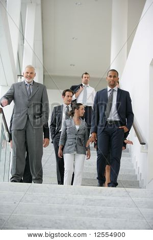 Geschäftsleute im Anzug kommen die Treppe hinunter