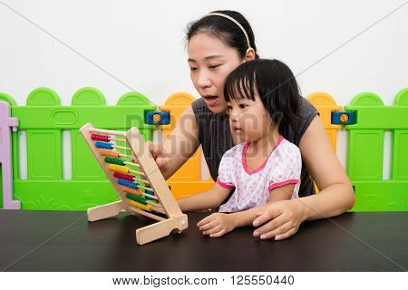Asian Little Chinese Girl And Mother Playing Abacus Together