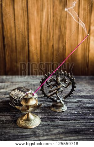 Incense in symbol and Beautiful Candlestick. Luxurious antique gold service. Spiritual religious Hindu concept. Eastern Still life on a blurred Background