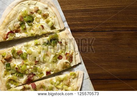 Homemade leek and bacon tarte flambee a traditional French and German oven baked pizza-like pie photographed overhead with natural light