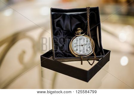 Black box with golden pocket watch on chain