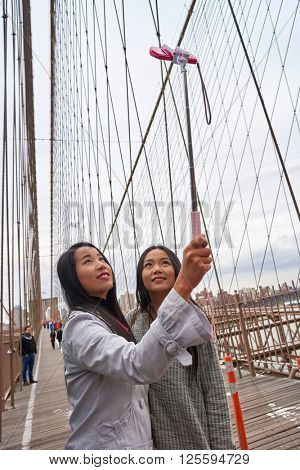 NEW-YORK - CIRCA MARCH 2016: women taking a selfie in New-York. A selfie is a self-portrait photograph, typically taken with a camera phone held in the hand or supported by a selfie stick.