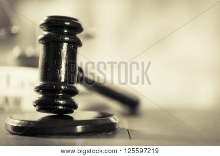 Wooden judges gavel on wooden table, close up. Retro stylization