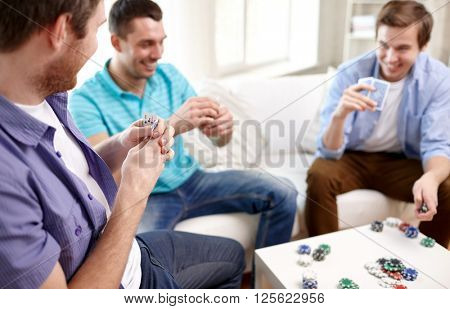 leisure, games, friendship, gambling and entertainment - close up of male friends playing cards at home