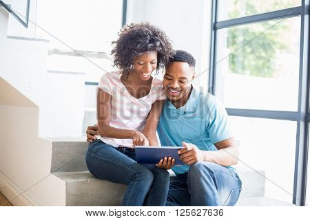Happy couple using digital tablet at home