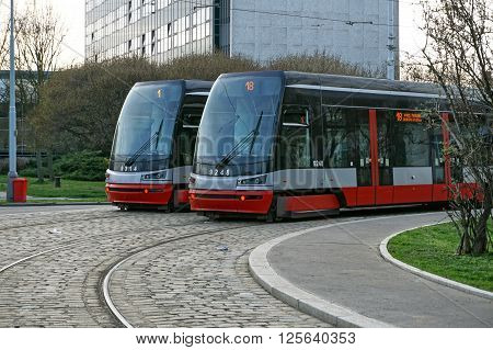 Two brand new trams on the parallel cobbled tracks in Prague, Czech republic