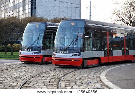 Two brand new trams on the parallel cobbled tracks in Prague, Czech republic
