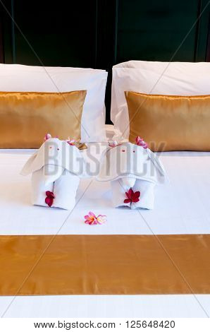 Elephant origami towel on the bed of a hotel.