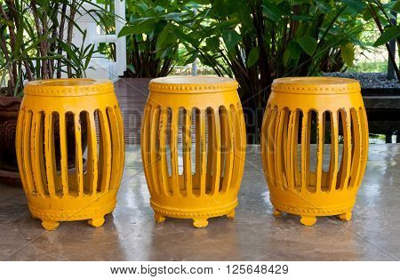 A row of yellow cylinder shape stools on the floor