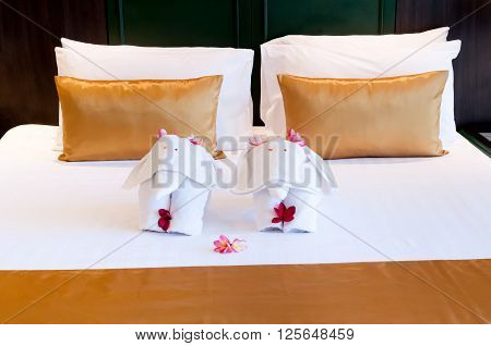 Elephant origami towel on the bed of a hotel.