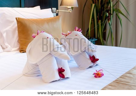 Elephant origami towel on the bed of a hotel.