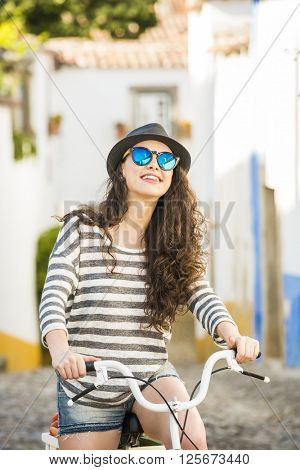 Happy beautiful female tourist riding a bicycle 