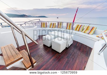 Yacht deck setup with white furnitures preparing for a group party.