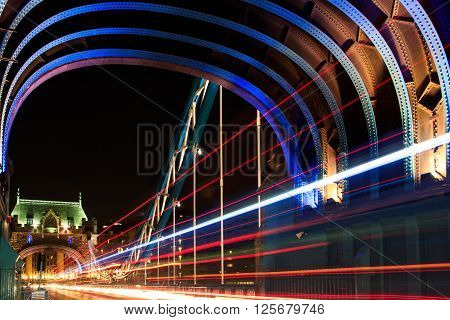London, UK - March 31, 2016 - Light trail of moving bus on Tower Bridge at night