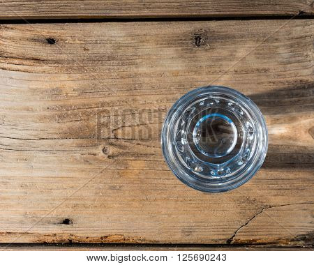 Glass of water on old wooden background