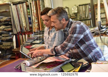 People in upholstery shop choosing sample