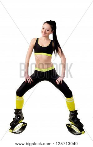slender smiling girl in kangoo jamps shoes doing exercises looks at the camera. Isolated on white background in studio