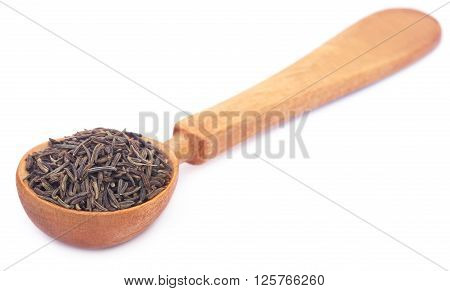 Caraway seeds in a wooden spoon over white background