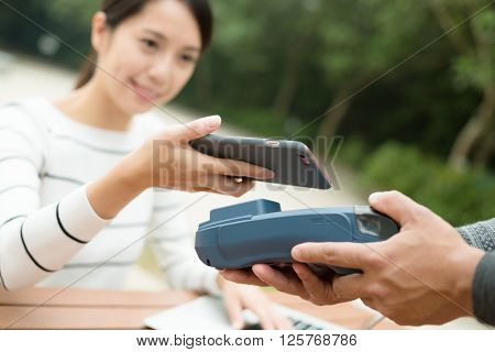 Woman pay with cellphone by NFC technology