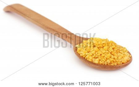 Mung dal in wooden spoon with selective focus