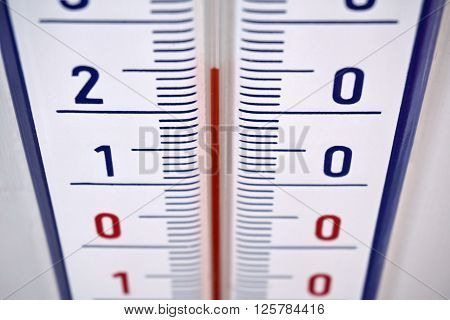 Aged outdoor thermometer in the retro design measuring mild temperature of twenty degrees of Celsius