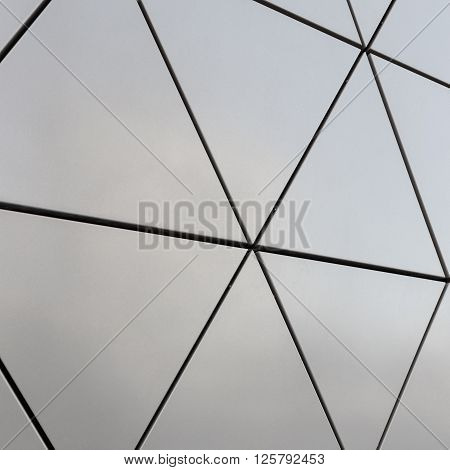 Abstract close-up view of modern aluminum ventilated facade of triangles