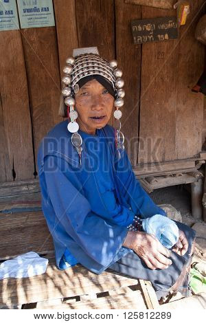 MAE SALONG,  CHIANG RAI province , THAILAND - JUN, 2004 : 
In the mountains of northern Thailand. An old woman from the Akha ethnic group. To save her money Akha women sew silver coins on headdress.