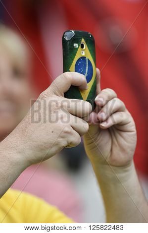 RIO DE JANEIRO BRAZIL - June 18 2014: secure mobile fan with cover of Brazil flag during the FIFA 2014 World Cup. Spain is facing Chile in the Group B at Maracana Stadium