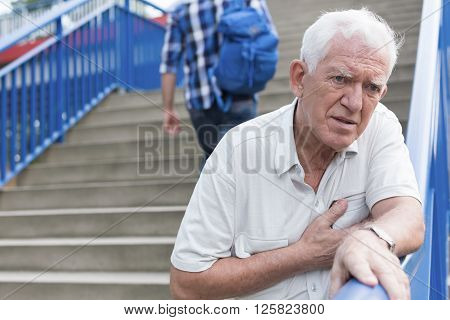 Senior weak man is walking down stairs