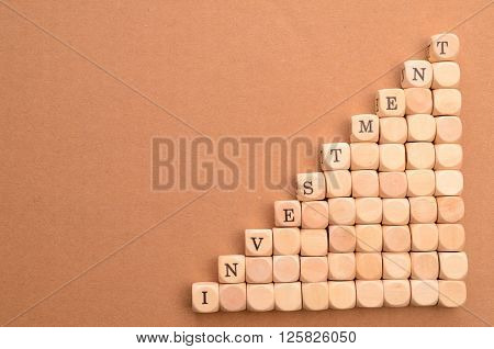 Wooden stairs with the word investment financial upswing concept on a cardboard background