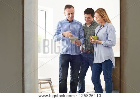 Couple Meeting With Architect Or Builder In Rennovated Property