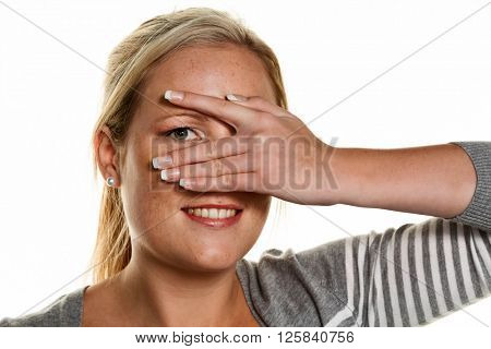 woman looks through fingers of her hand