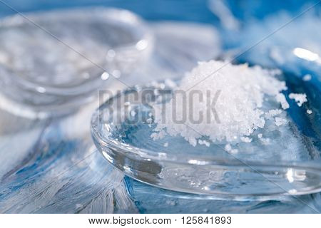 Fleur de sel sea salt sea salt with glass heart on blue abstract painted background