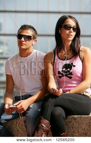 Ritratto di un giovane uomo e una donna giovane, ascoltando la musica con un walkman mp3