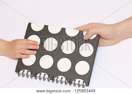 mother's hand pass black polka dots sealed spring notebook in hand Children