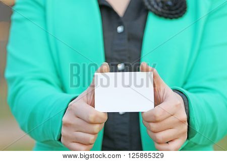 she holds in both hands a business card to display the card