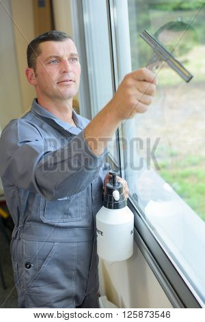 Man cleaning window with squeegee