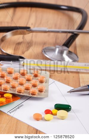 Medical pills tablets or supplements for therapy prescription thermometer and stethoscope on desk in doctor office