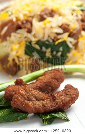 Fried rice with fried pork on white plate