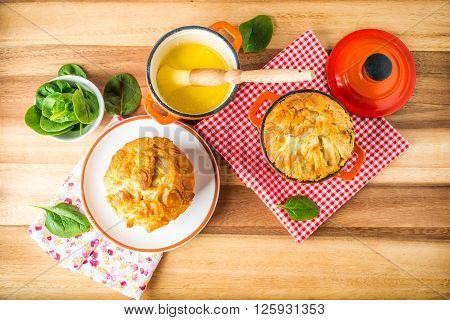 Spanakopita - Greek spinach pie with feta and ricotta baked in cast iron pots with melted butter