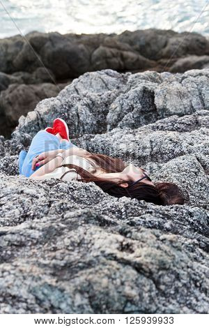 Girl sleeping at reef on background of the bay Puket in Thailand
